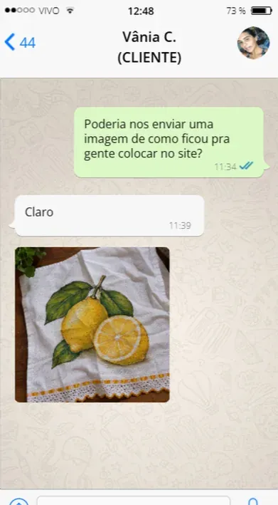 Cliente mostrando uma pintura de limões em pano de prato
